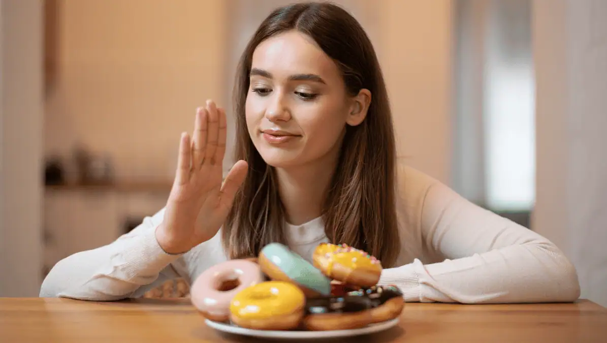 Appetite Control Woman staring at a plate of doughnuts