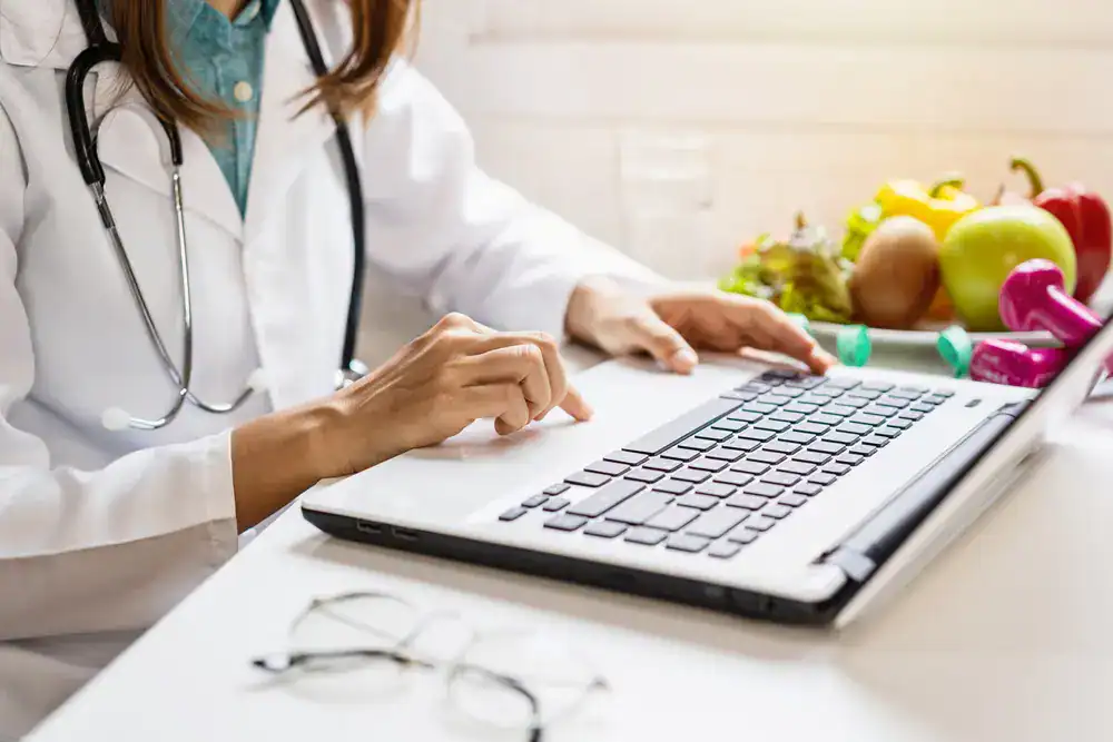 Weight Loss Treatment_Sarasota Medical professional using a laptop for weight loss consultation or research.