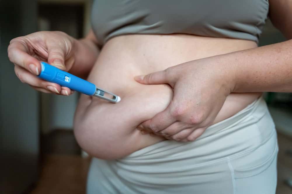 Weight Loss Treatment in Lakeland Person measuring abdominal fat with a glucose meter for weight loss.
