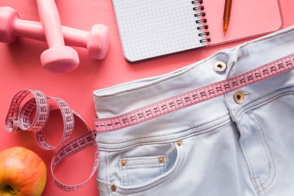 Weight Loss Tools and Accessories Fitness and weight loss accessories on pink background.